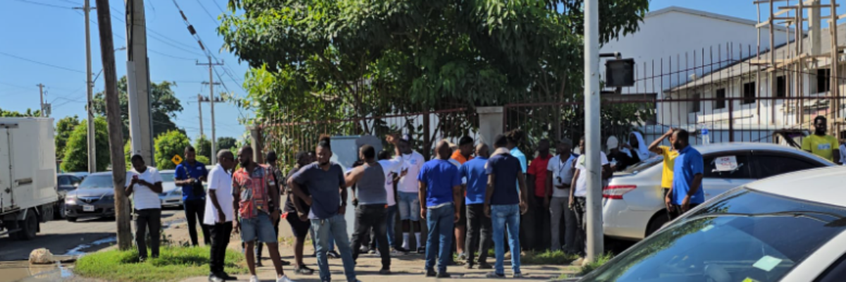 Taxi operators block Spanish Town Road in Kingston in protest of poor road conditions and raw sewage on the roadway