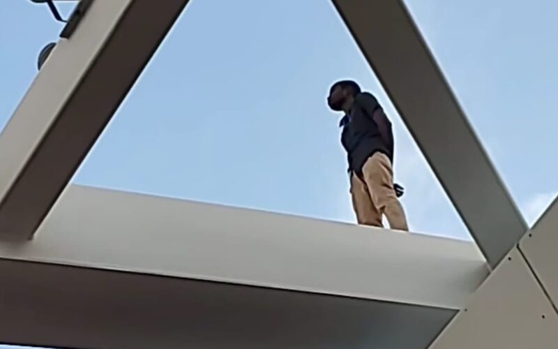 Former firefighter back to safety after climbing atop HWT Transport Centre